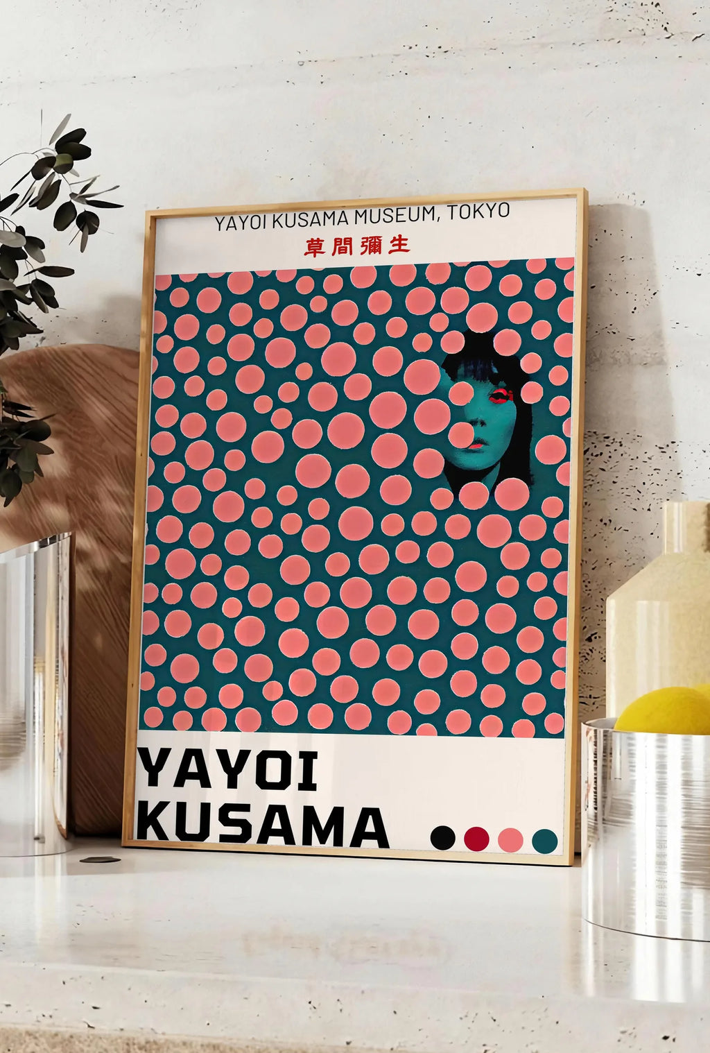 Affiche affiche pois corail de Kusama art japonais, posee sur un plan de travail de cuisine en pierre claire, entre une branche d'eucalyptus en vase et un bocal de citrons