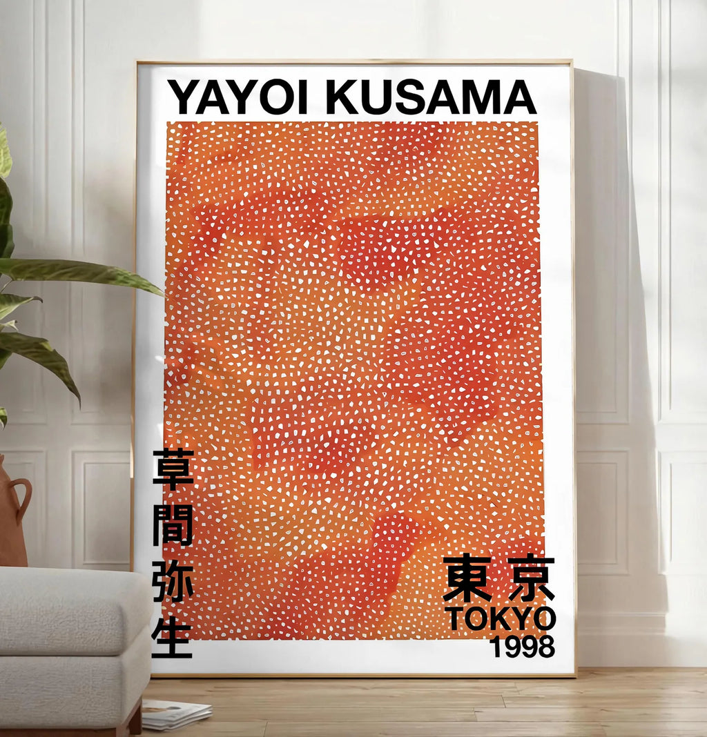 Reproduction affiche pois orange de Kusama art japonais, posee au sol dans un salon minimaliste clair, a cote d'un canape beige et d'une plante verte, sur un parquet clair