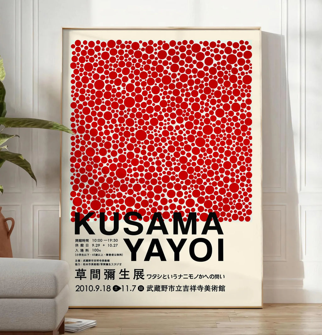 Reproduction affiche pois rouges de Kusama art japonais, posee au sol dans un salon minimaliste clair, a cote d'un canape beige et d'une plante verte, sur un parquet clair