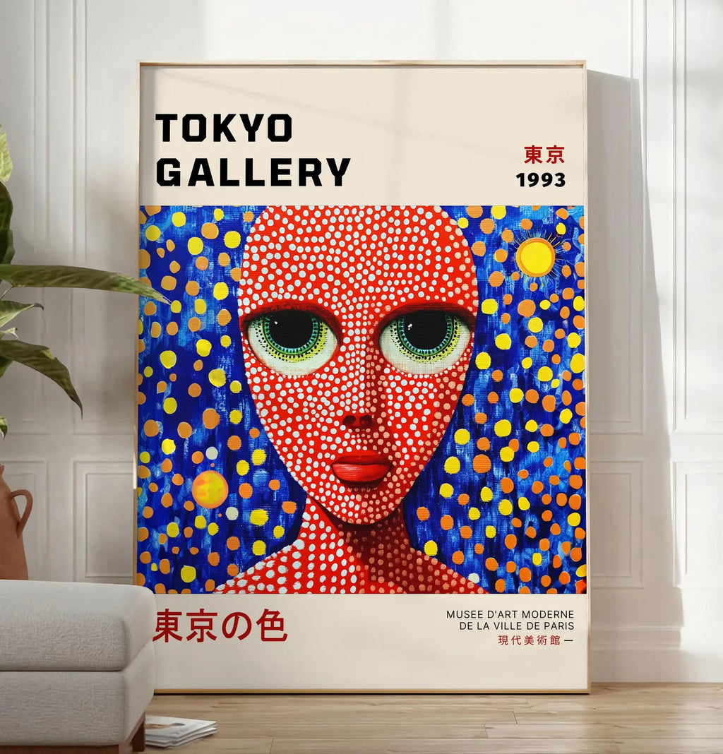 Reproduction affiche visage de femme a pois de Kusama art japonais, posee au sol dans un salon minimaliste clair, a cote d'un canape beige et d'une plante verte, sur un parquet clair