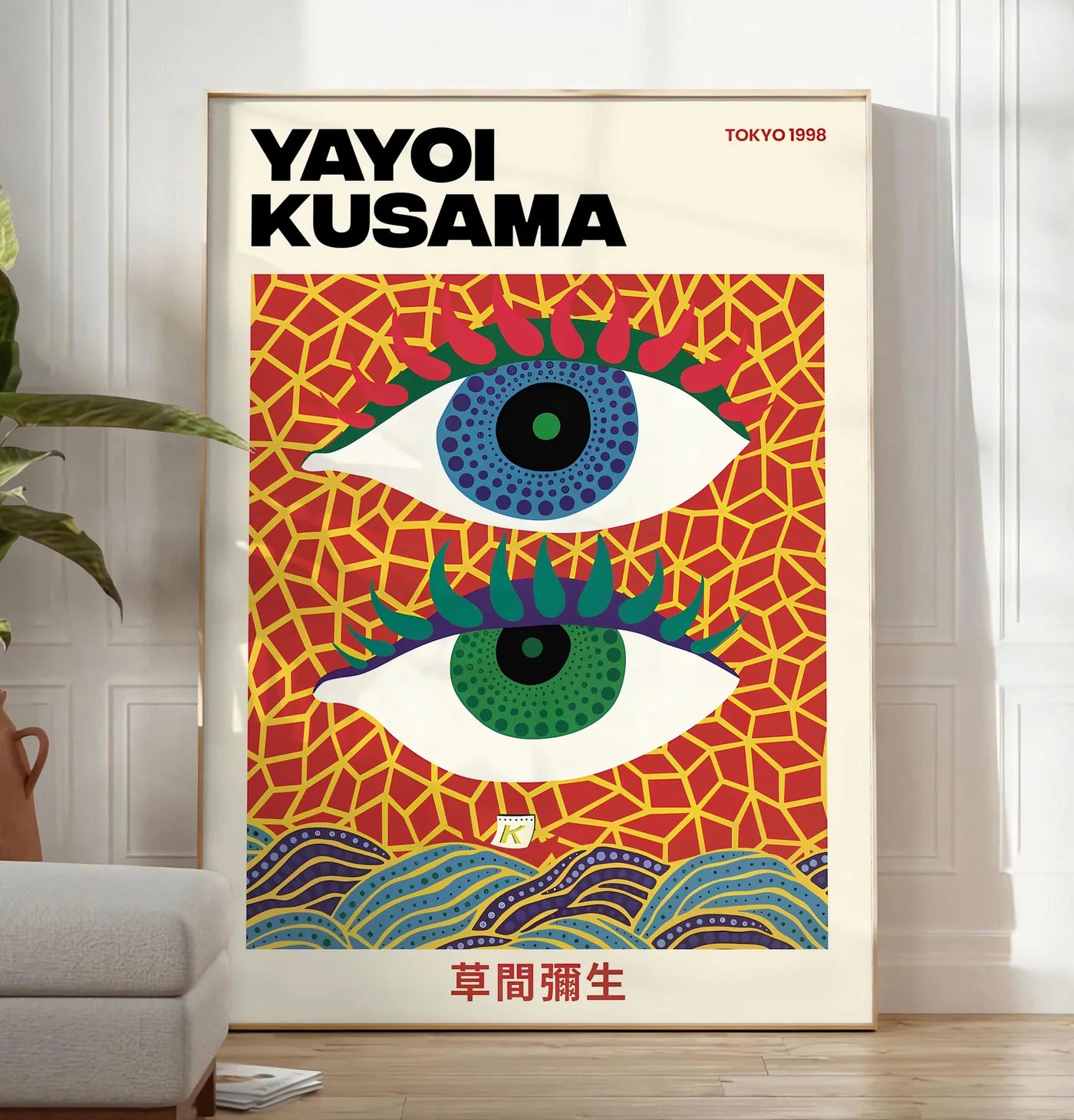 Reproduction affiche yeux a pois de Kusama art japonais, posee au sol dans un salon minimaliste clair, a cote d'un canape beige et d'une plante verte, sur un parquet clair