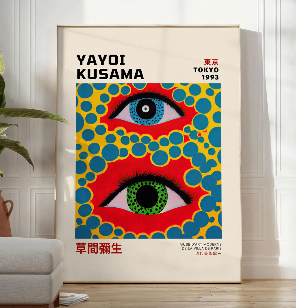 Reproduction affiche yeux a pois jaune de Kusama art japonais, posee au sol dans un salon minimaliste clair, a cote d'un canape beige et d'une plante verte, sur un parquet clair