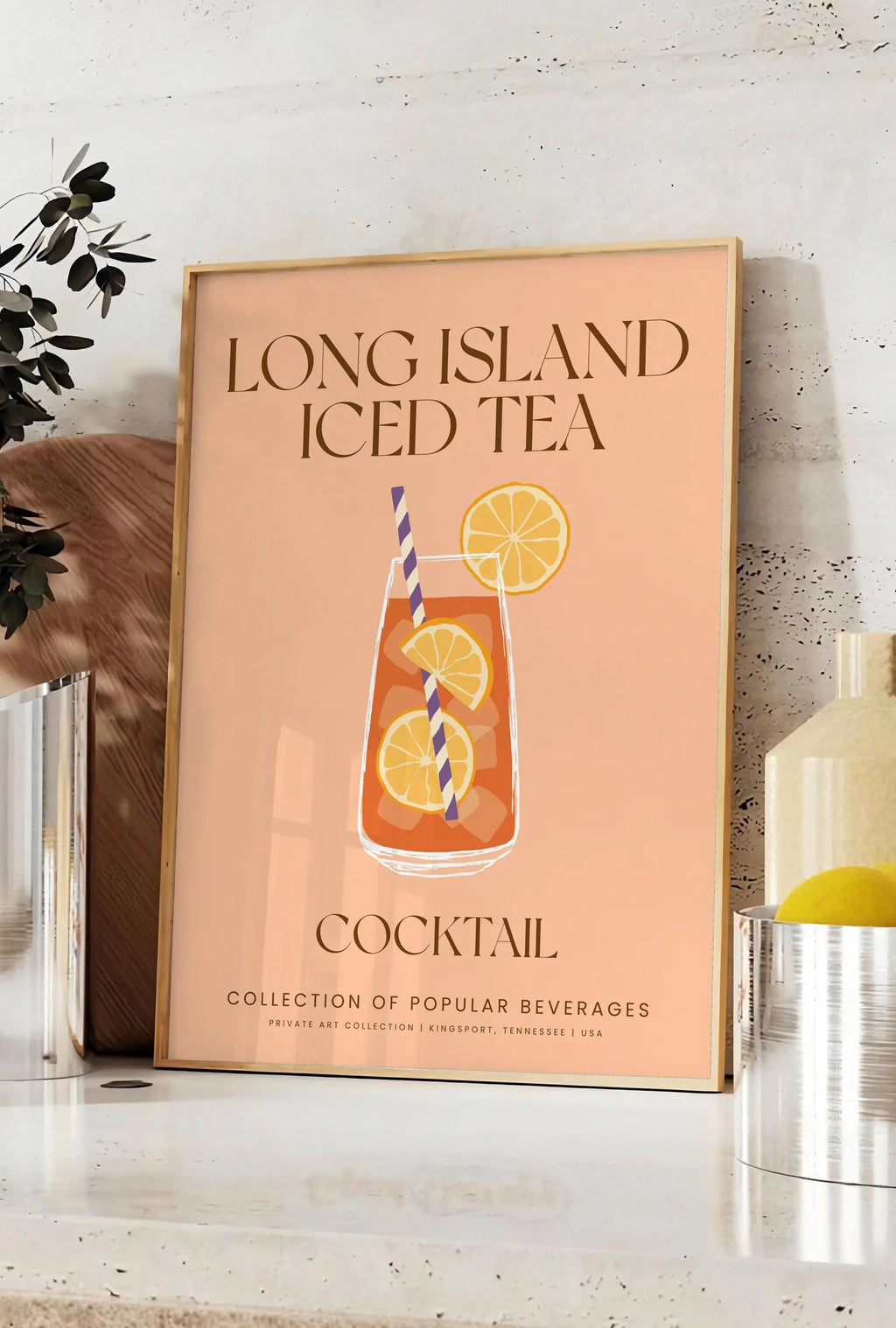 Affiche affiche cocktail Long Island Iced Tea, posee sur un plan de travail de cuisine en pierre claire, entre une branche d'eucalyptus en vase et un bocal de citrons