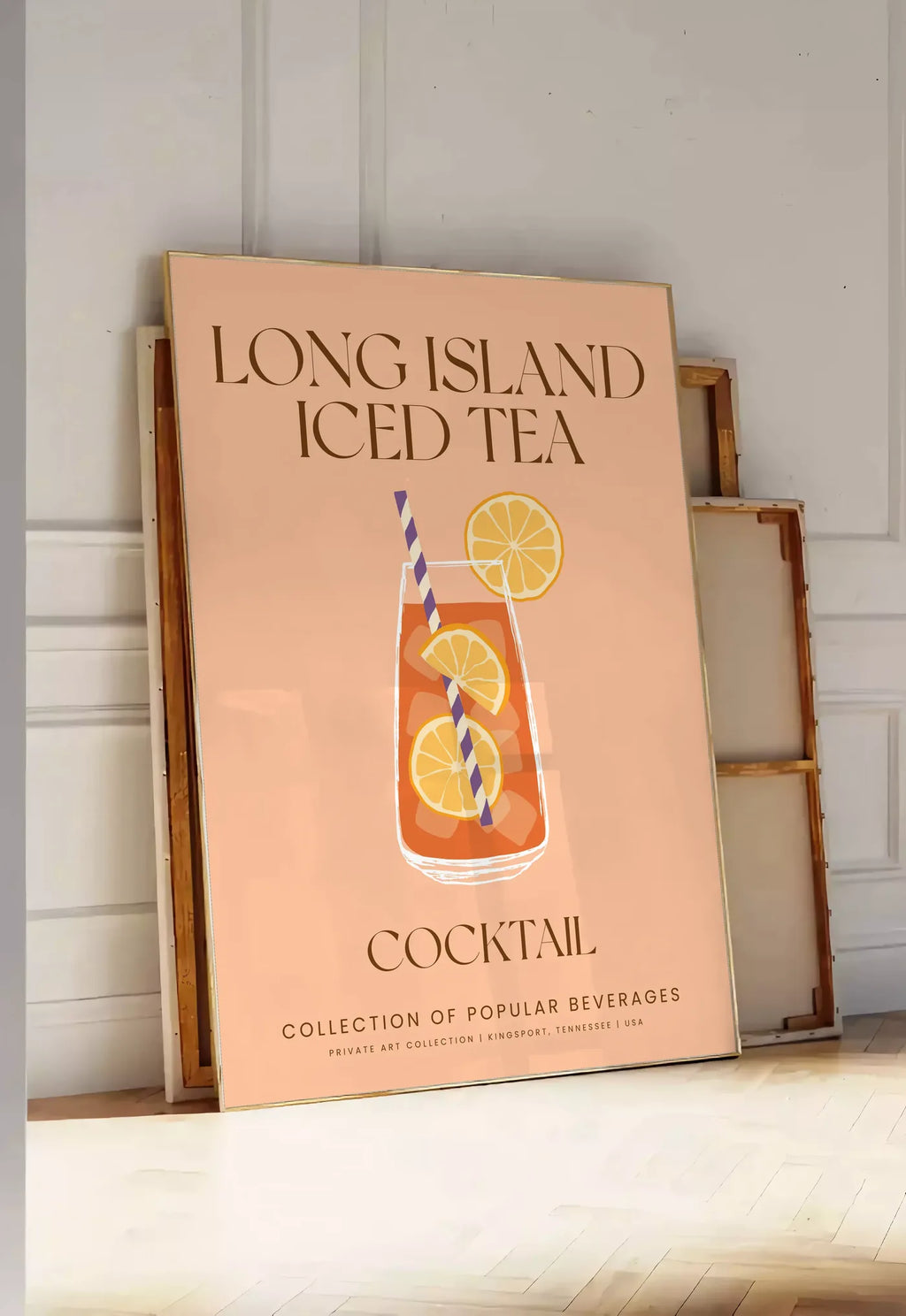 Tirage encadrable affiche cocktail Long Island Iced Tea, posee au sol dans une entree lumineuse, contre un mur a panneaux blancs, a cote de chassis en bois empiles
