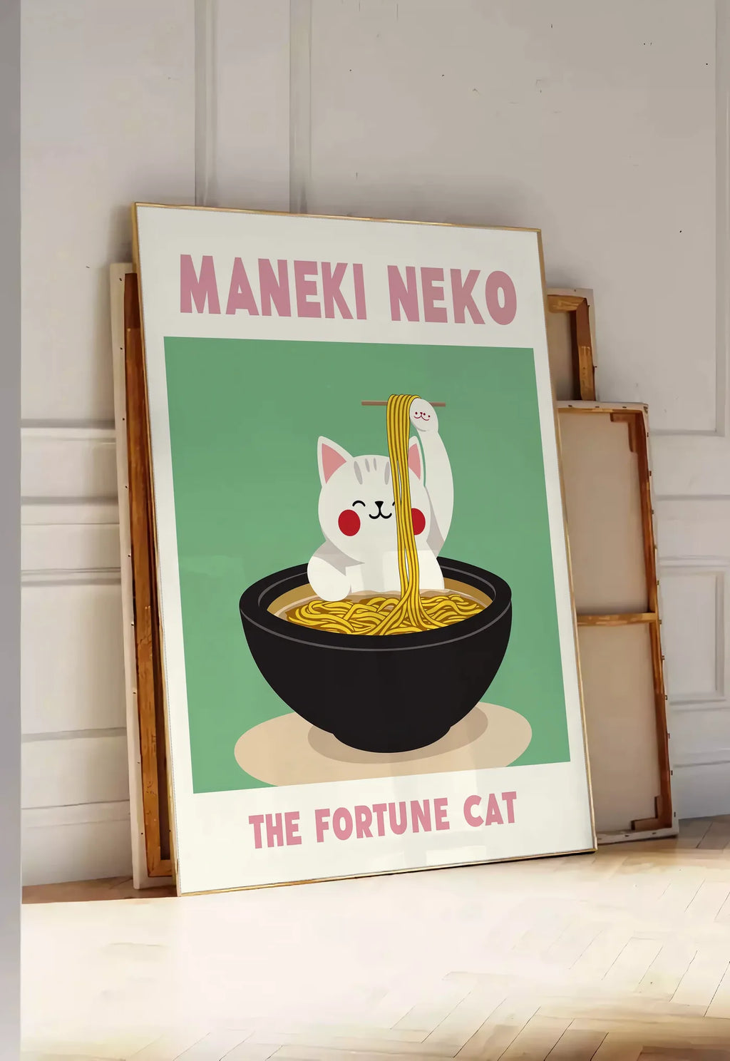 Tirage encadrable affiche Maneki Neko chat et ramen sur fond vert sauge, posee au sol dans une entree lumineuse, contre un mur a panneaux blancs, a cote de chassis en bois empiles