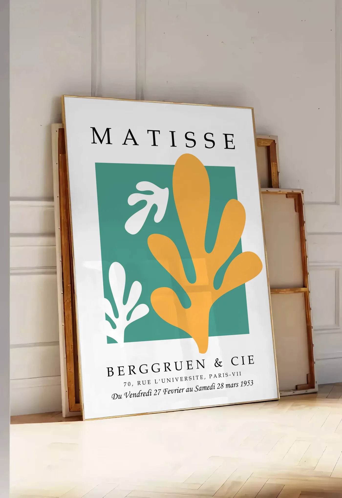 Tirage encadrable corail Jaune sur Vert en papiers decoupes Matisse sur fond colore, posee au sol dans une entree lumineuse, contre un mur a panneaux blancs, a cote de chassis en bois empiles