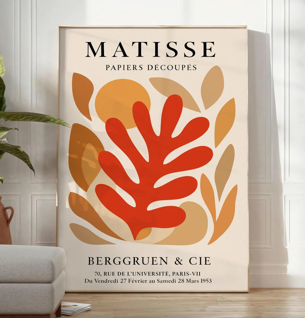 Reproduction corail Rouge Tons Automne en papiers decoupes Matisse sur fond colore, posee au sol dans un salon minimaliste clair, a cote d'un canape beige et d'une plante verte, sur un parquet clair
