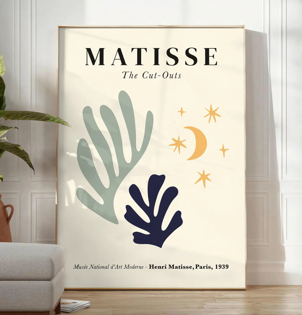 Reproduction corail Lune et Etoiles en papiers decoupes Matisse sur fond colore, posee au sol dans un salon minimaliste clair, a cote d'un canape beige et d'une plante verte, sur un parquet clair