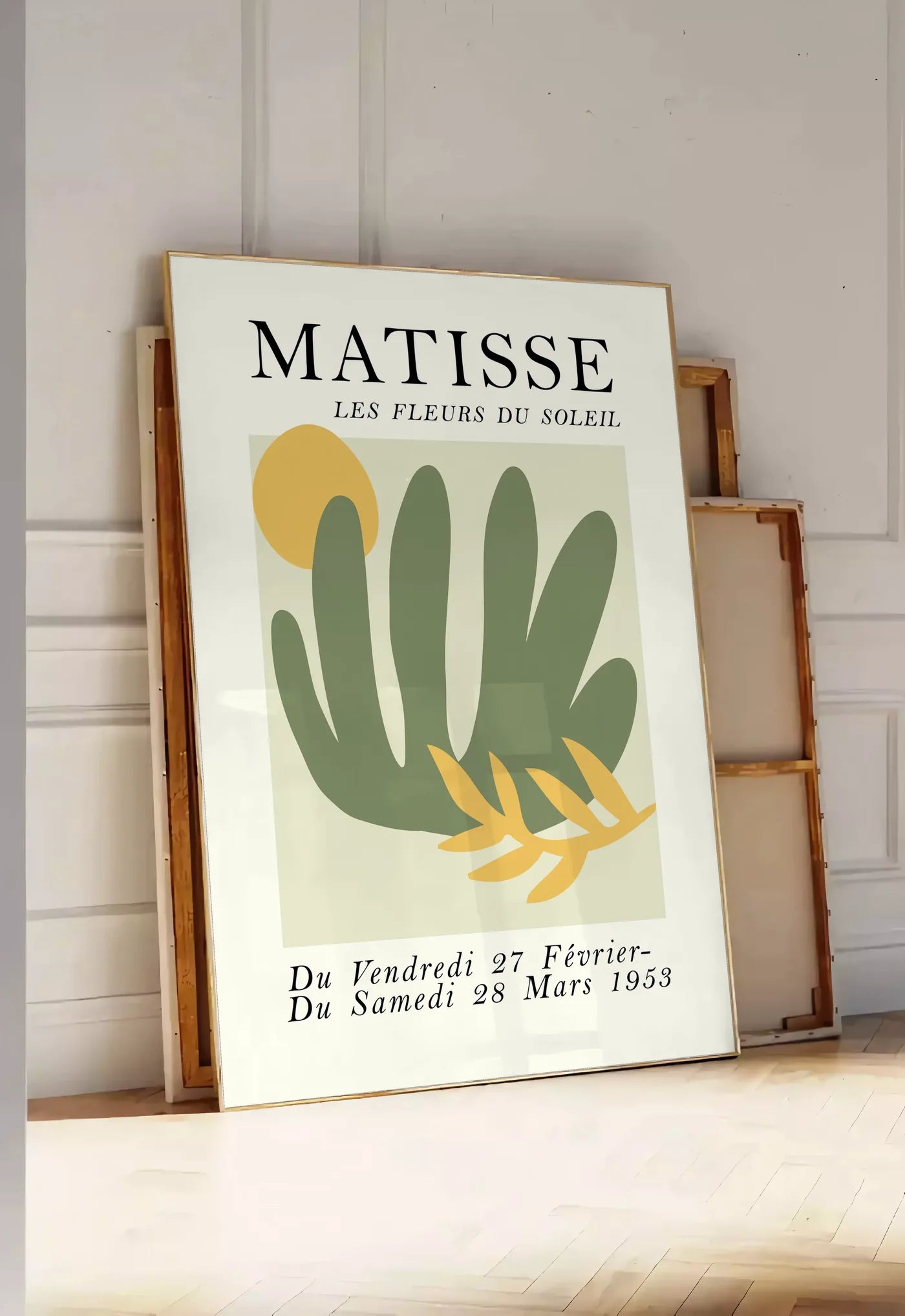 Tirage encadrable les Fleurs du Soleil en papiers decoupes Matisse sur fond colore, posee au sol dans une entree lumineuse, contre un mur a panneaux blancs, a cote de chassis en bois empiles