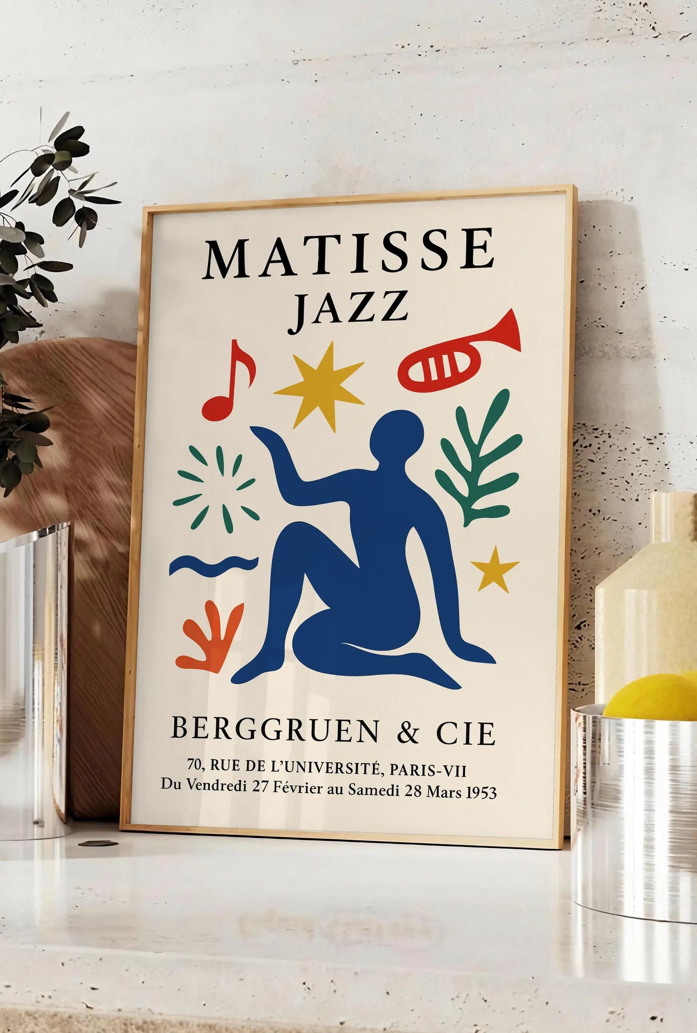 Affiche affiche Matisse Jazz, posee sur un plan de travail de cuisine en pierre claire, entre une branche d'eucalyptus en vase et un bocal de citrons