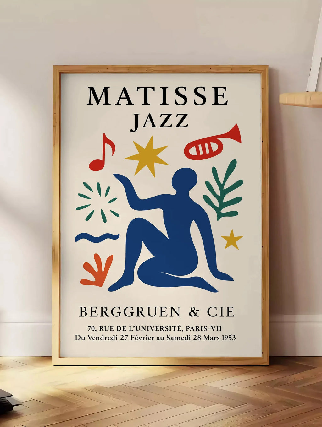 Estampe affiche Matisse Jazz, posee au sol dans un coin salon, sur un parquet a chevrons, pres d'une table d'appoint en chene chargee de livres