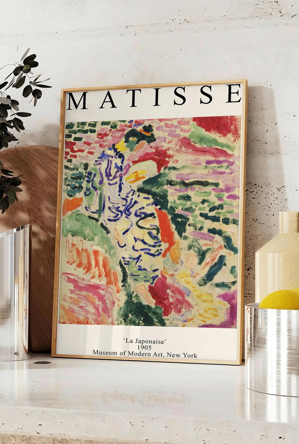 Affiche matisse La Japonaise 1905, posee sur un plan de travail de cuisine en pierre claire, entre une branche d'eucalyptus en vase et un bocal de citrons