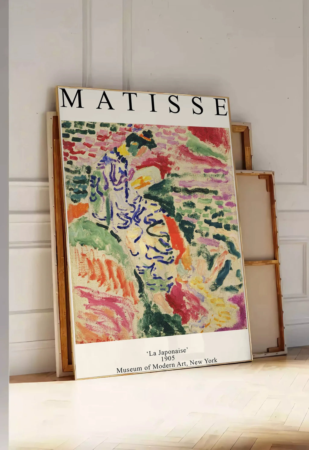 Tirage encadrable matisse La Japonaise 1905, posee au sol dans une entree lumineuse, contre un mur a panneaux blancs, a cote de chassis en bois empiles