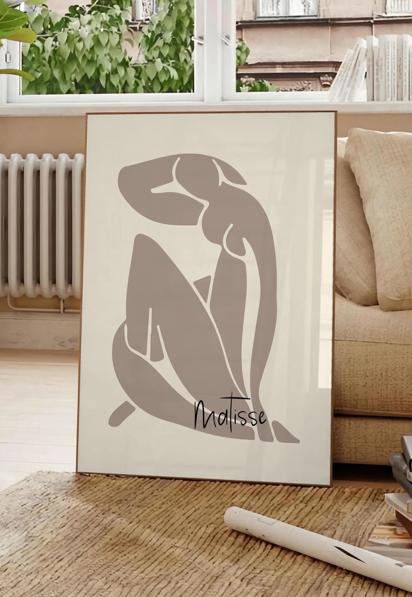 Poster nu assis taupe au trait blanc sur fond creme, posee au sol dans un salon parisien, devant une grande fenetre donnant sur un immeuble haussmannien, entre un ficus et un canape creme