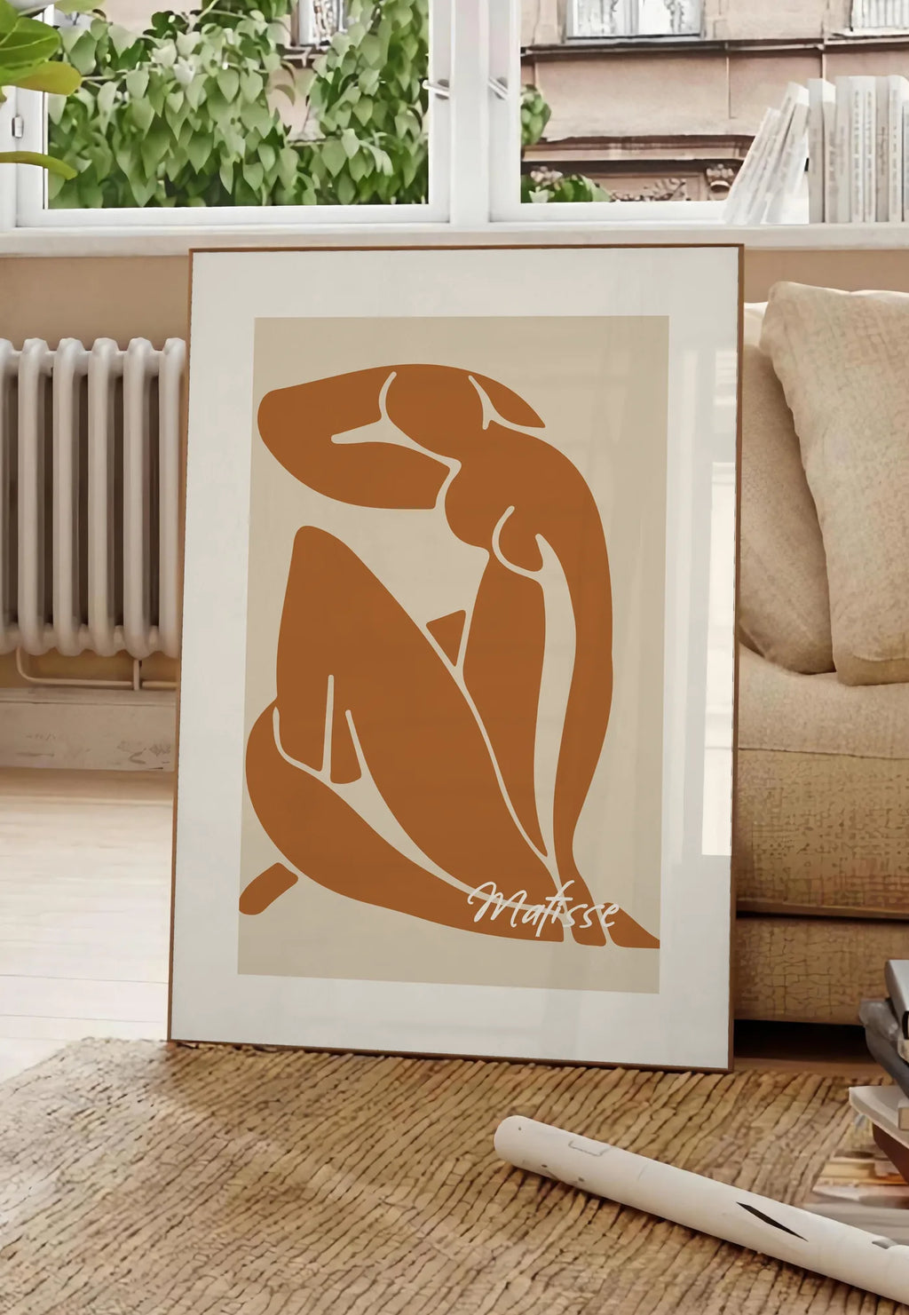 Poster affiche Matisse, posee au sol dans un salon parisien, devant une grande fenetre donnant sur un immeuble haussmannien, entre un ficus et un canape creme