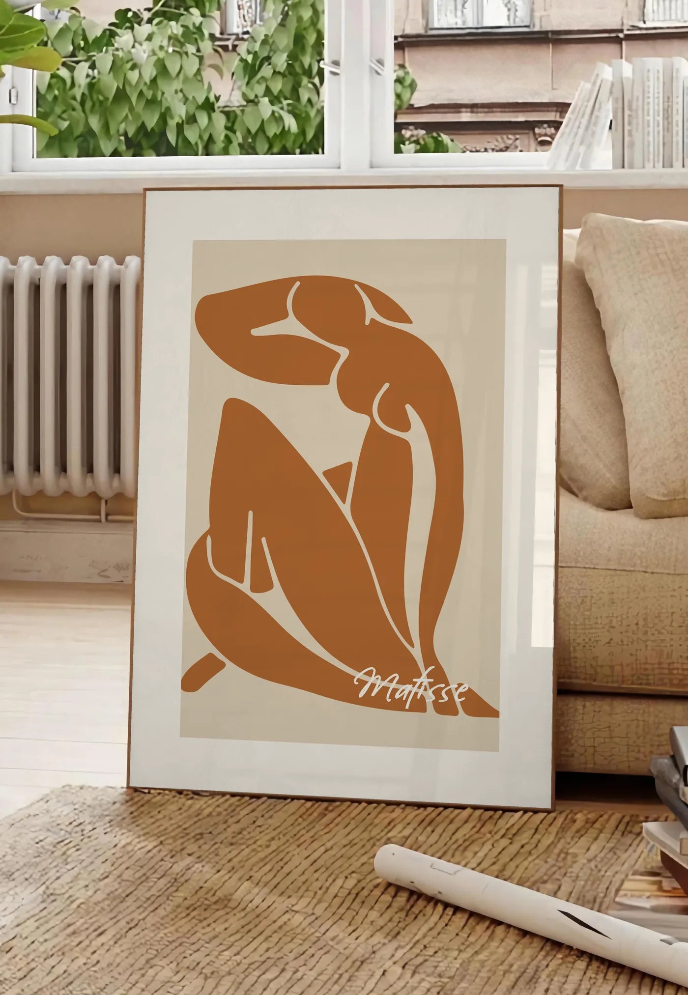 Poster affiche Matisse, posee au sol dans un salon parisien, devant une grande fenetre donnant sur un immeuble haussmannien, entre un ficus et un canape creme