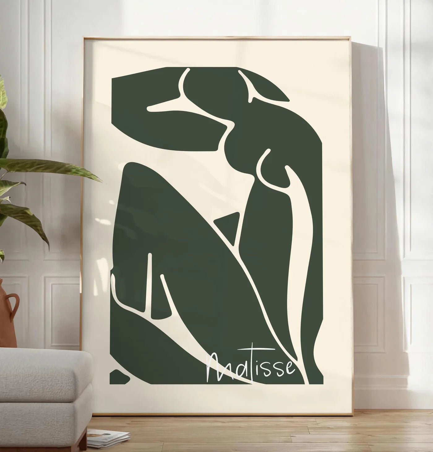 Reproduction nu assis vert au trait blanc sur fond creme, posee au sol dans un salon minimaliste clair, a cote d'un canape beige et d'une plante verte, sur un parquet clair