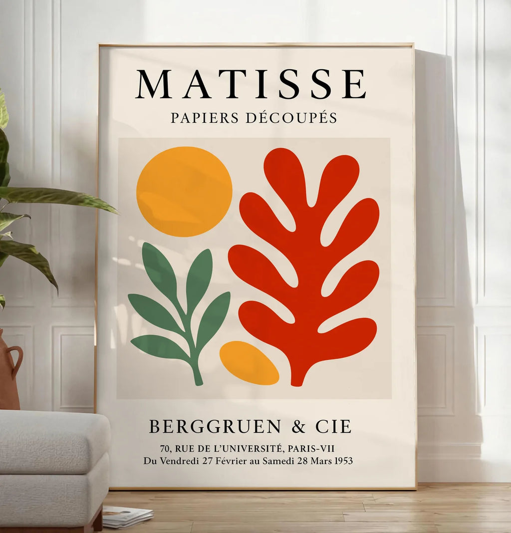 Reproduction disque Branche et Corail Rouge en papiers decoupes Matisse sur fond colore, posee au sol dans un salon minimaliste clair, a cote d'un canape beige et d'une plante verte, sur un parquet clair