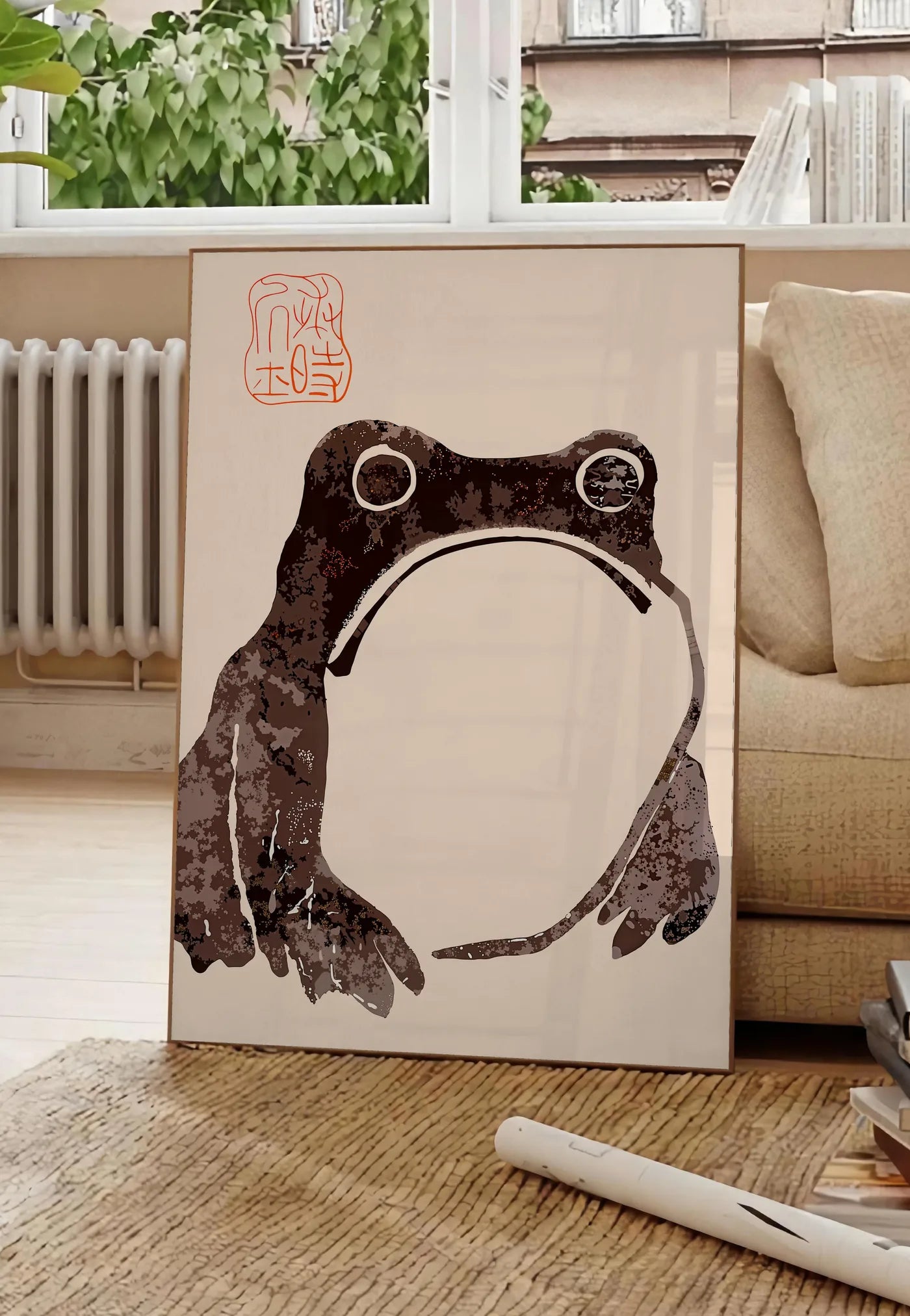 Poster affiche grenouille blasee de Matsumoto Hoji, posee au sol dans un salon parisien, devant une grande fenetre donnant sur un immeuble haussmannien, entre un ficus et un canape creme