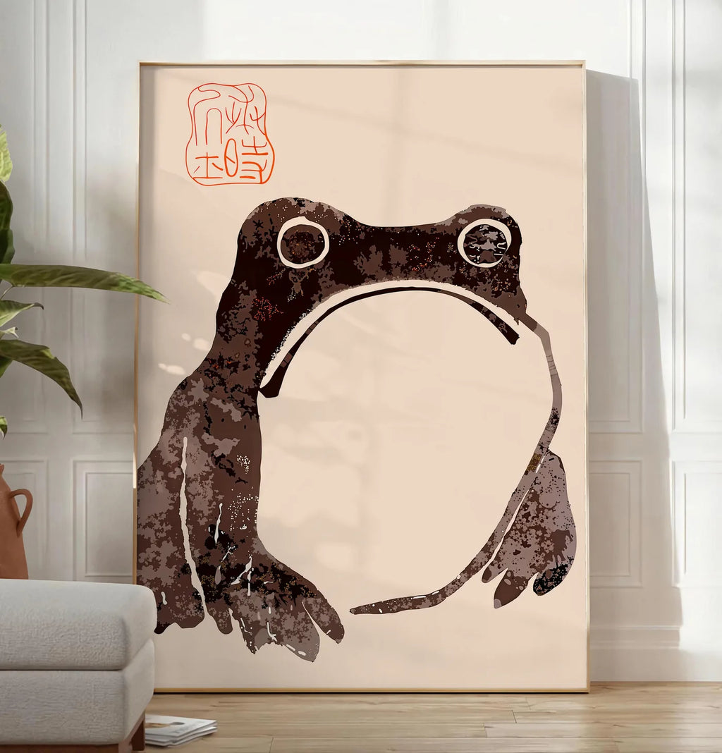 Reproduction affiche grenouille blasee de Matsumoto Hoji, posee au sol dans un salon minimaliste clair, a cote d'un canape beige et d'une plante verte, sur un parquet clair