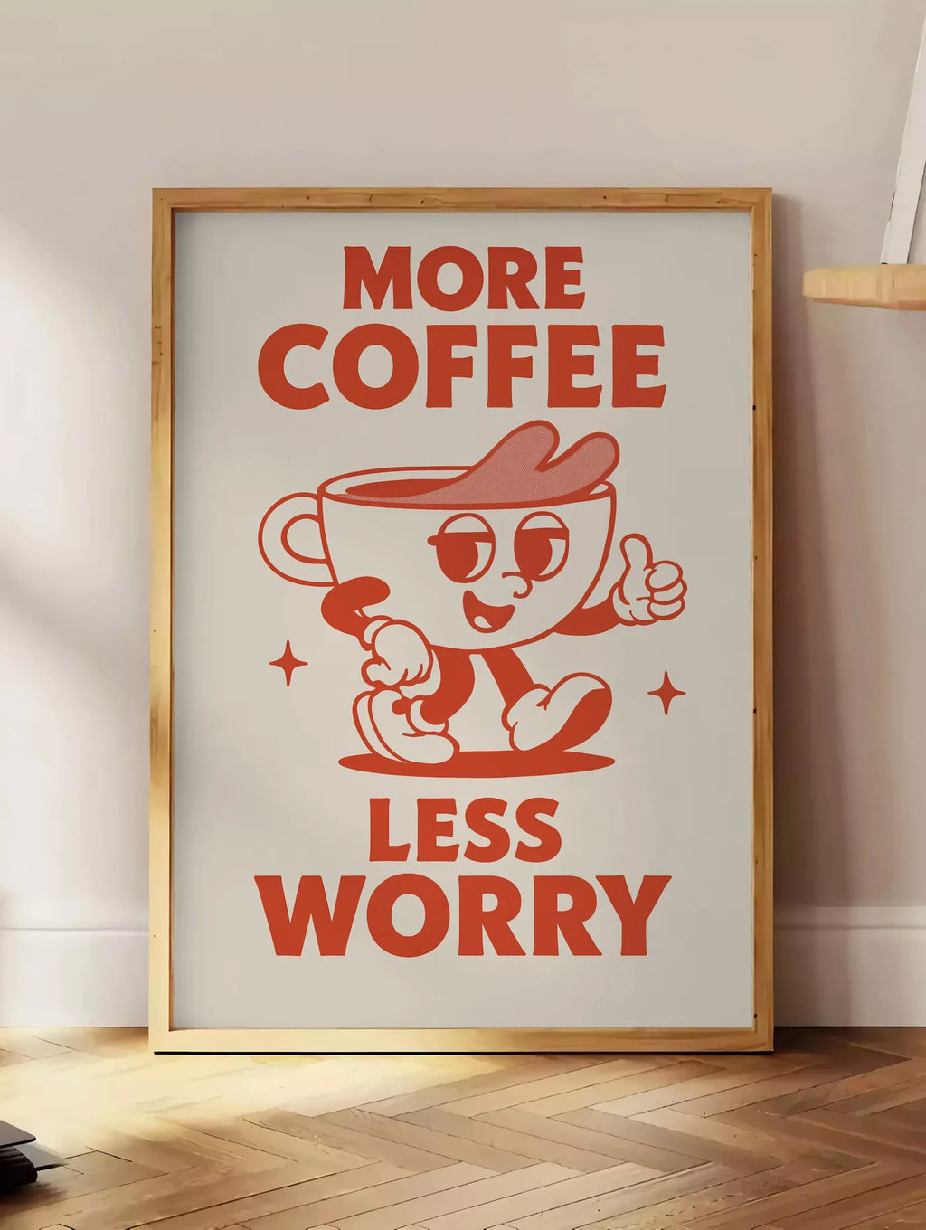 Estampe affiche cuisine cafe More Coffee Less Worry, posee au sol dans un coin salon, sur un parquet a chevrons, pres d'une table d'appoint en chene chargee de livres