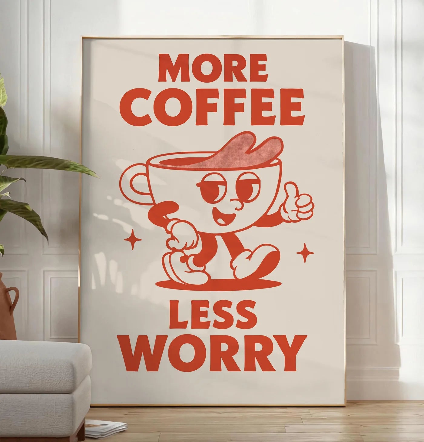 Reproduction affiche cuisine cafe More Coffee Less Worry, posee au sol dans un salon minimaliste clair, a cote d'un canape beige et d'une plante verte, sur un parquet clair