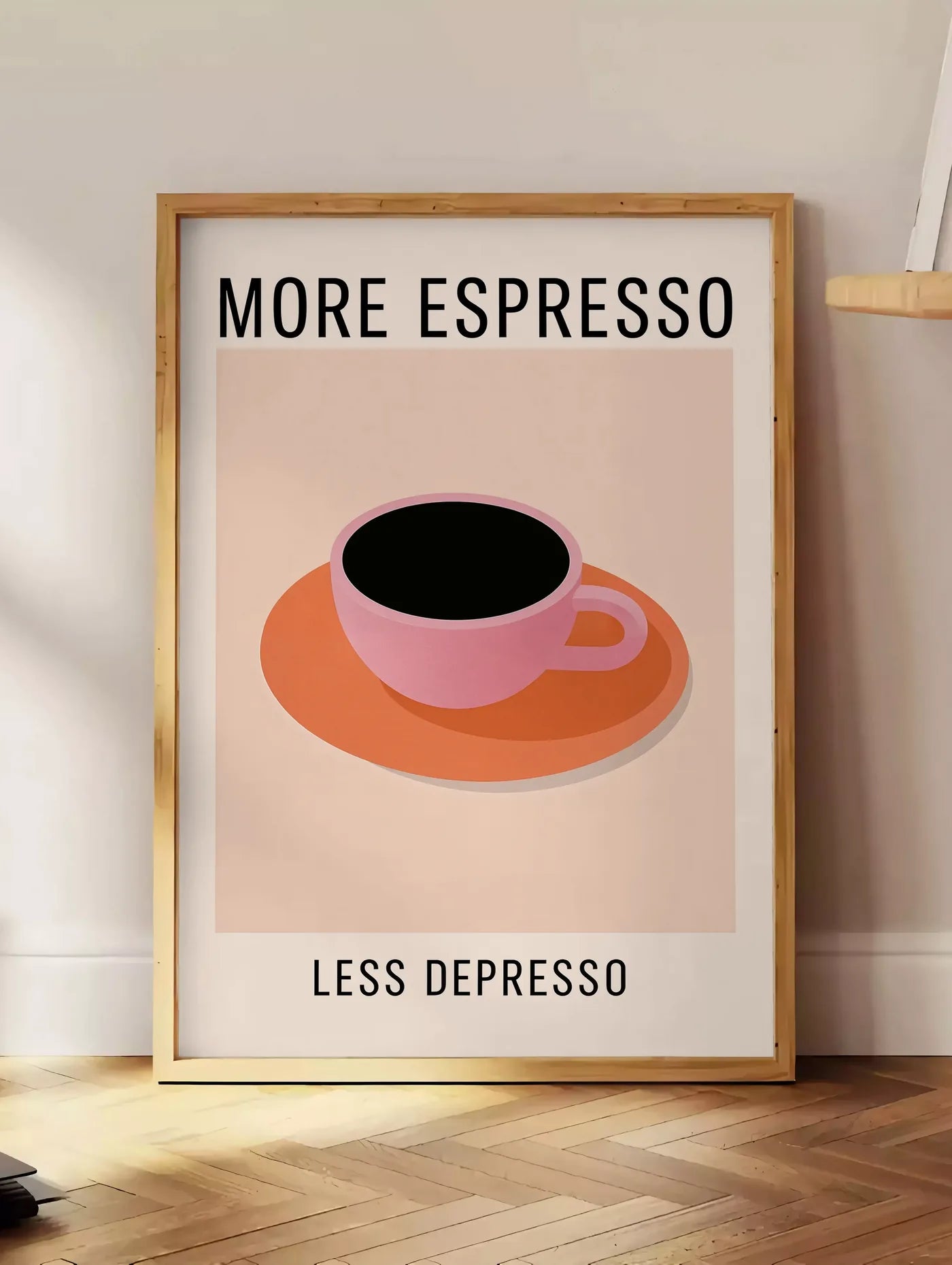 Estampe affiche cuisine cafe More Espresso, posee au sol dans un coin salon, sur un parquet a chevrons, pres d'une table d'appoint en chene chargee de livres