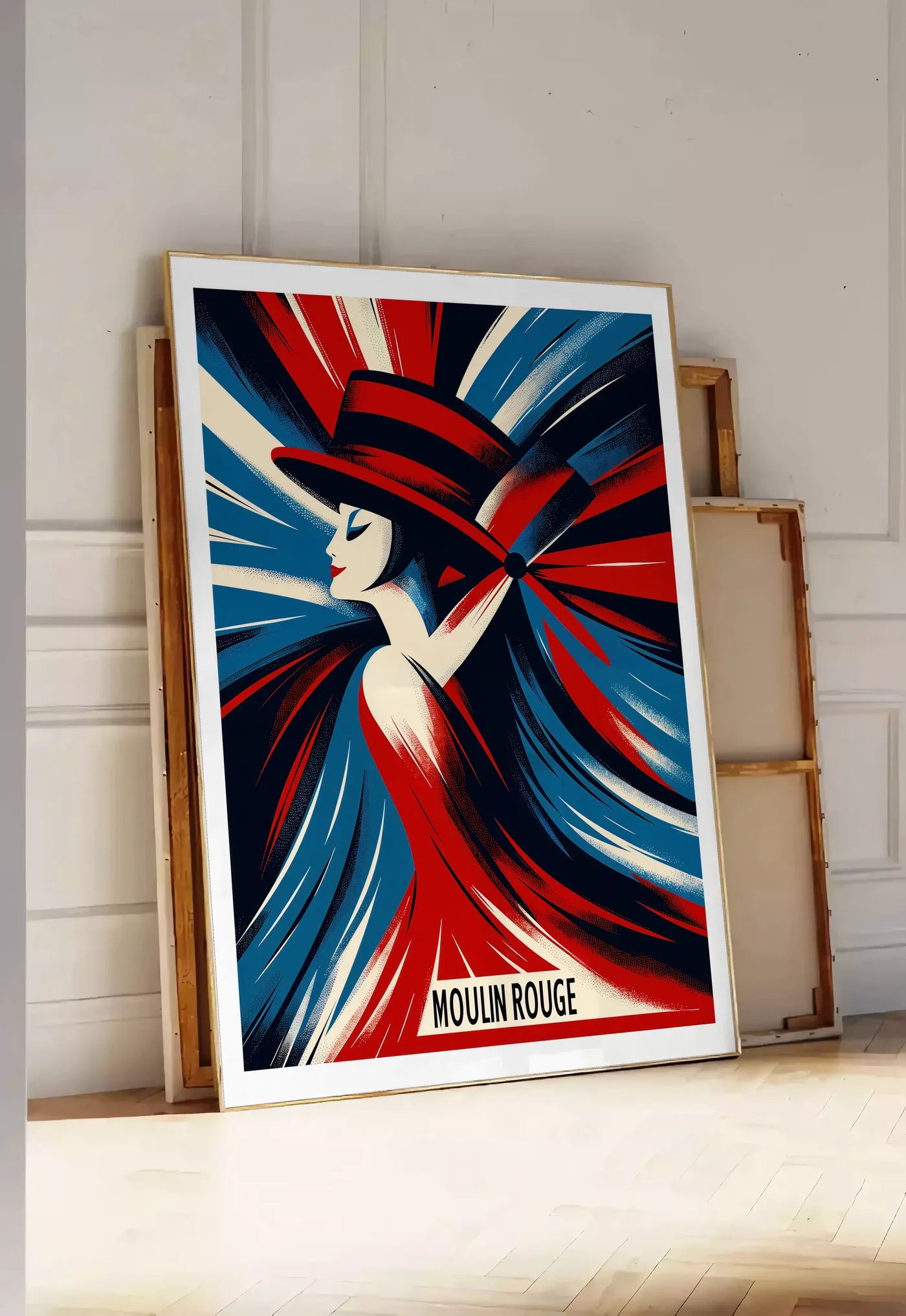Tirage encadrable affiche Moulin Rouge Art Deco, posee au sol dans une entree lumineuse, contre un mur a panneaux blancs, a cote de chassis en bois empiles