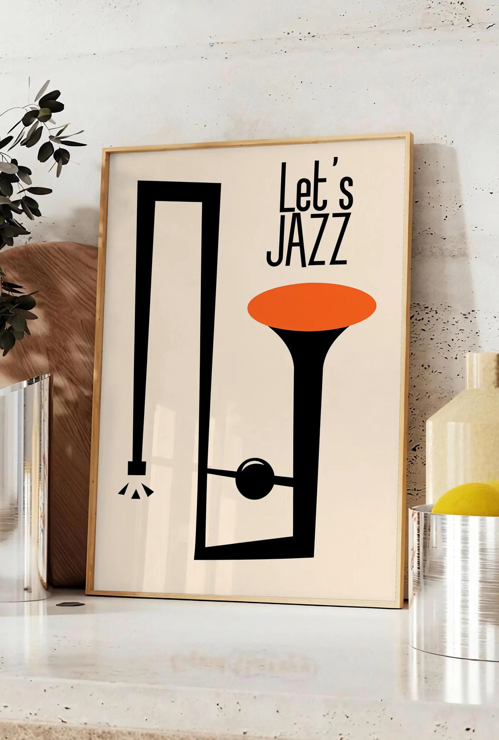 Affiche affiche jazz minimaliste, posee sur un plan de travail de cuisine en pierre claire, entre une branche d'eucalyptus en vase et un bocal de citrons
