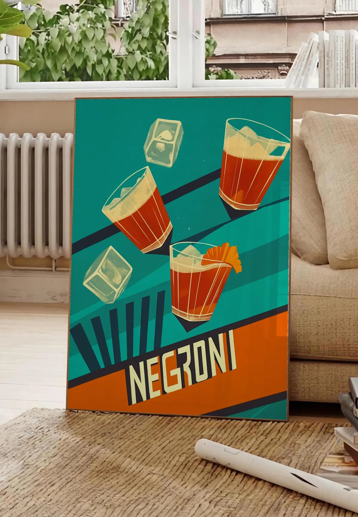 Poster affiche cocktail Negroni, posee au sol dans un salon parisien, devant une grande fenetre donnant sur un immeuble haussmannien, entre un ficus et un canape creme