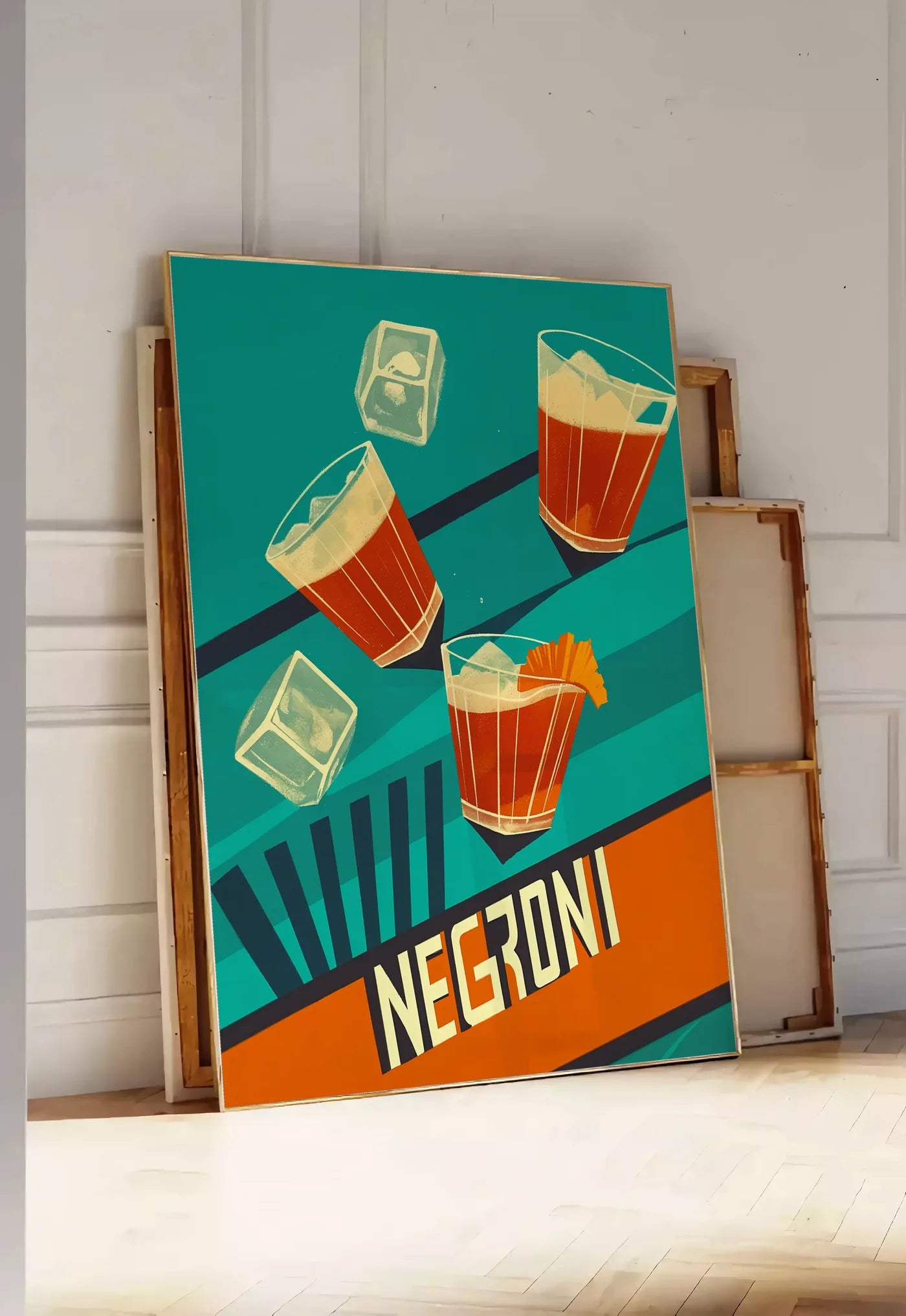 Tirage encadrable affiche cocktail Negroni, posee au sol dans une entree lumineuse, contre un mur a panneaux blancs, a cote de chassis en bois empiles