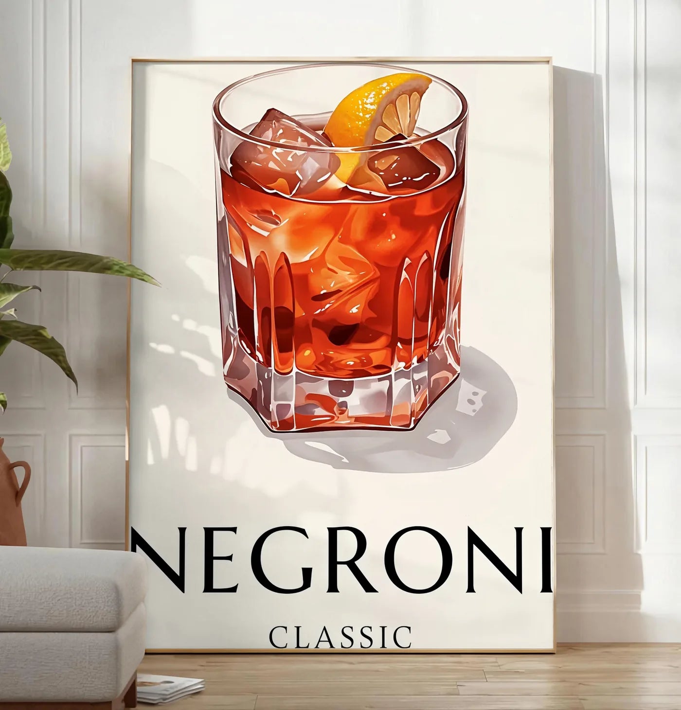 Reproduction affiche cocktail Negroni, posee au sol dans un salon minimaliste clair, a cote d'un canape beige et d'une plante verte, sur un parquet clair
