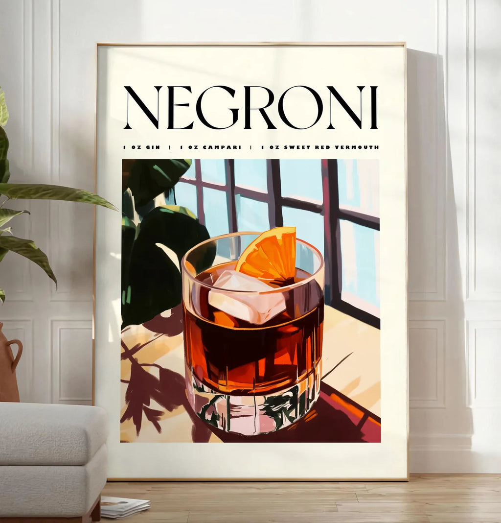 Reproduction affiche cocktail Negroni, posee au sol dans un salon minimaliste clair, a cote d'un canape beige et d'une plante verte, sur un parquet clair