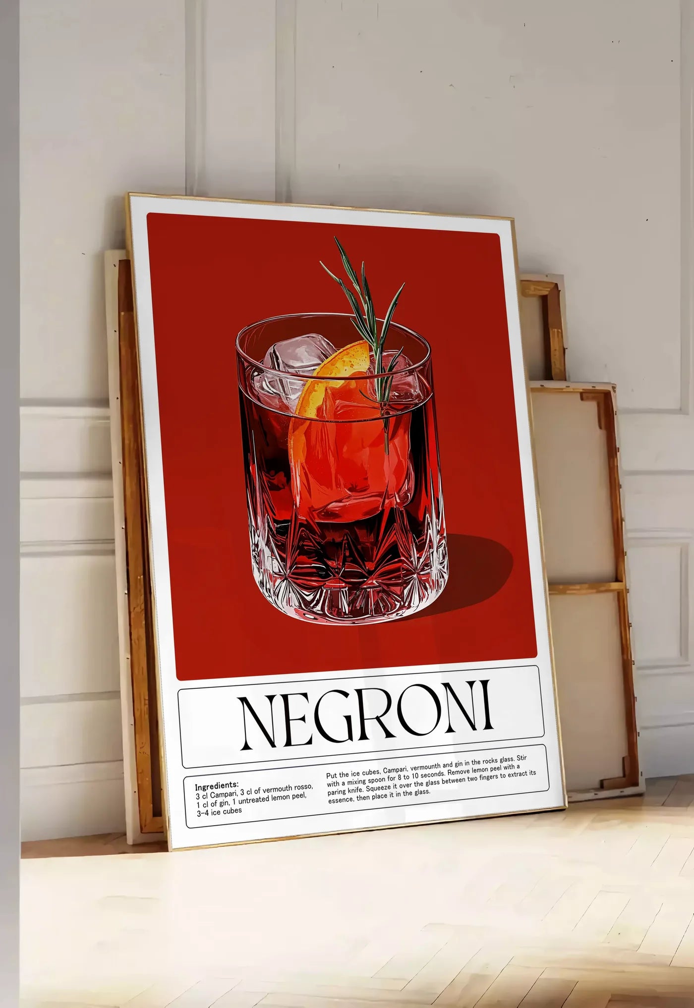 Tirage encadrable affiche cocktail Negroni, posee au sol dans une entree lumineuse, contre un mur a panneaux blancs, a cote de chassis en bois empiles