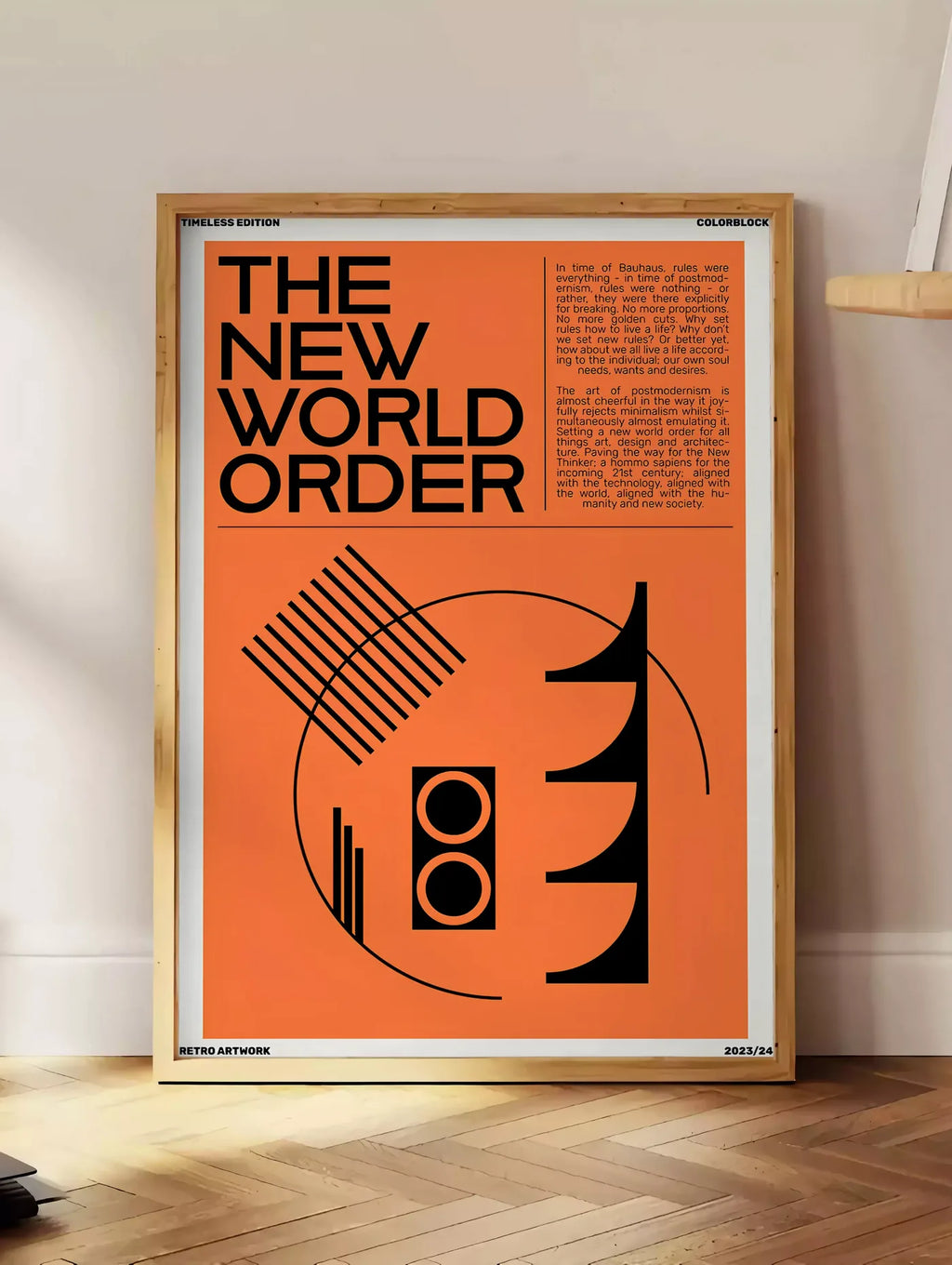 Estampe typographie The New World Order en noir sur orange, posee au sol dans un coin salon, sur un parquet a chevrons, pres d'une table d'appoint en chene chargee de livres