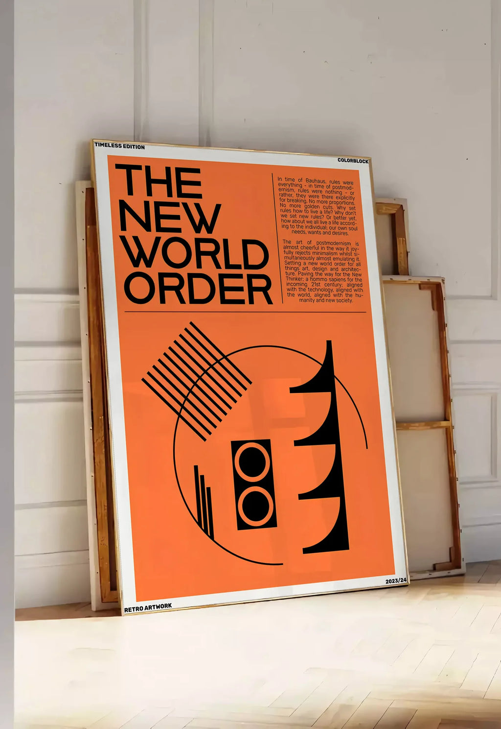 Tirage encadrable typographie The New World Order en noir sur orange, posee au sol dans une entree lumineuse, contre un mur a panneaux blancs, a cote de chassis en bois empiles