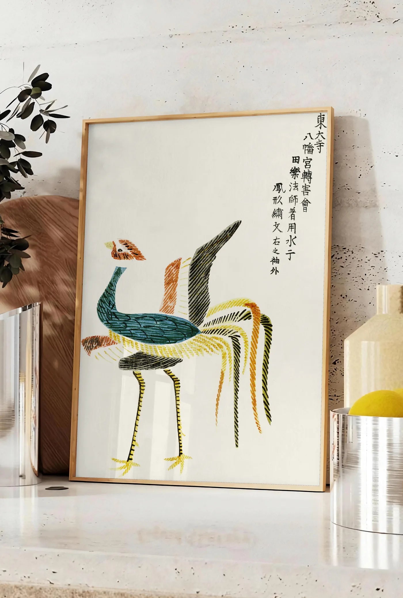 Affiche affiche grues stylisees vintage art japonais, posee sur un plan de travail de cuisine en pierre claire, entre une branche d'eucalyptus en vase et un bocal de citrons