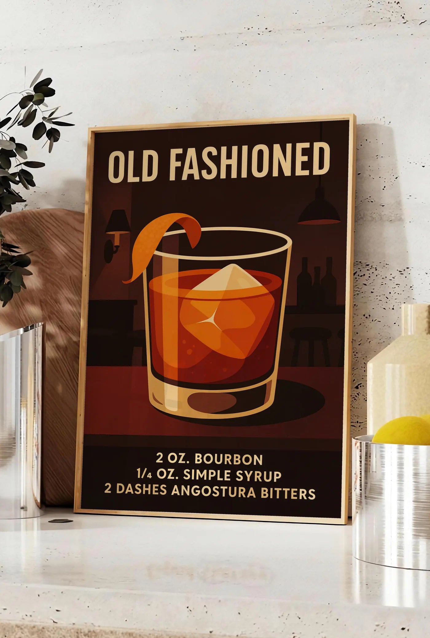 Affiche affiche cocktail Old Fashioned, posee sur un plan de travail de cuisine en pierre claire, entre une branche d'eucalyptus en vase et un bocal de citrons