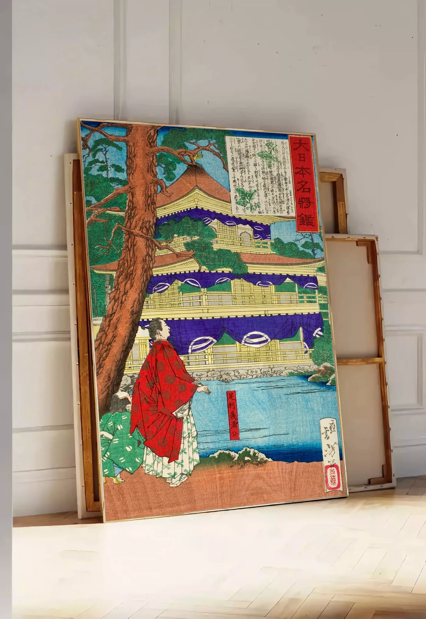 Tirage encadrable affiche pavillon dore et samurai art japonais, posee au sol dans une entree lumineuse, contre un mur a panneaux blancs, a cote de chassis en bois empiles