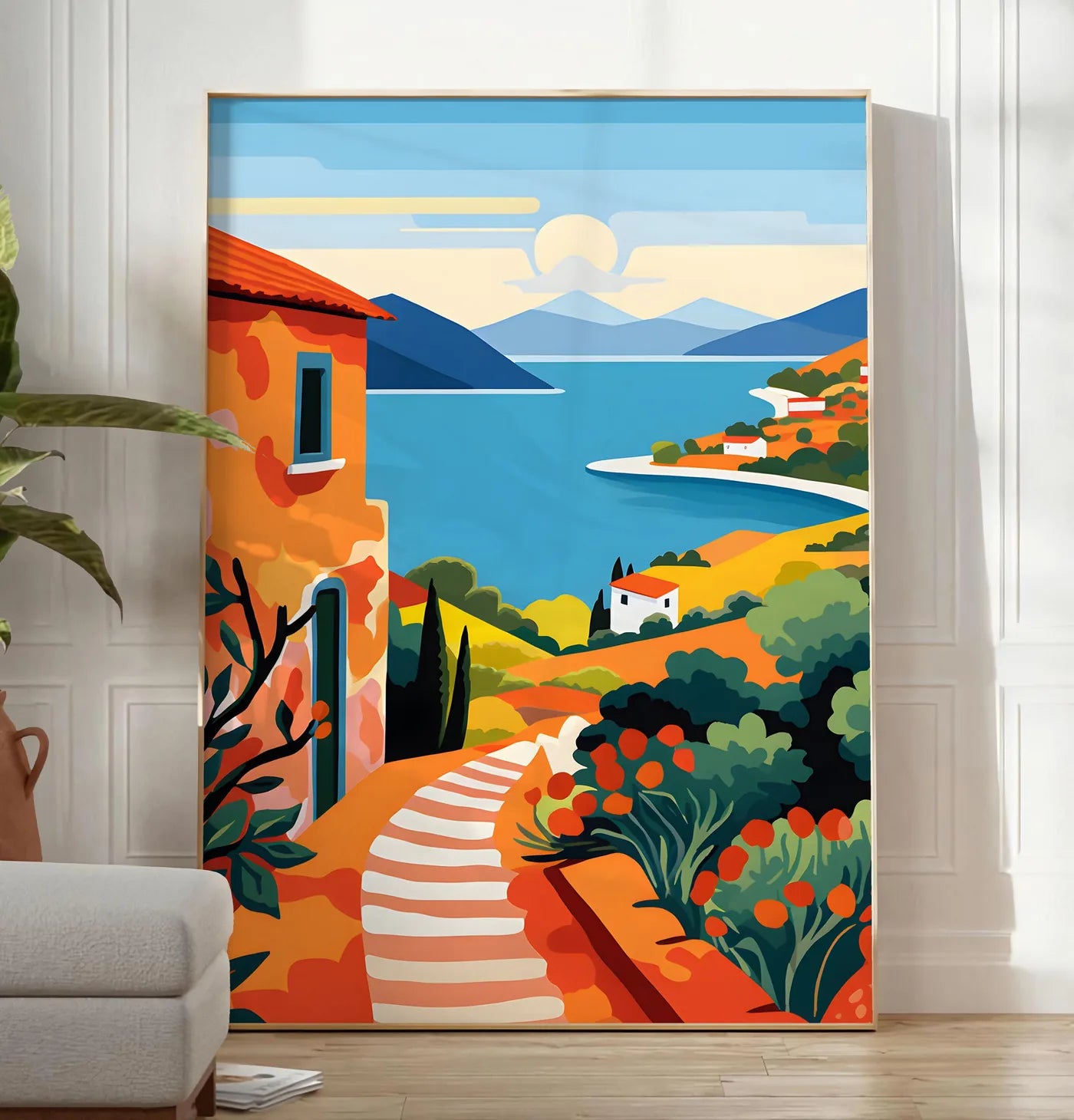 Reproduction affiche paysage cote mediterranee, posee au sol dans un salon minimaliste clair, a cote d'un canape beige et d'une plante verte, sur un parquet clair