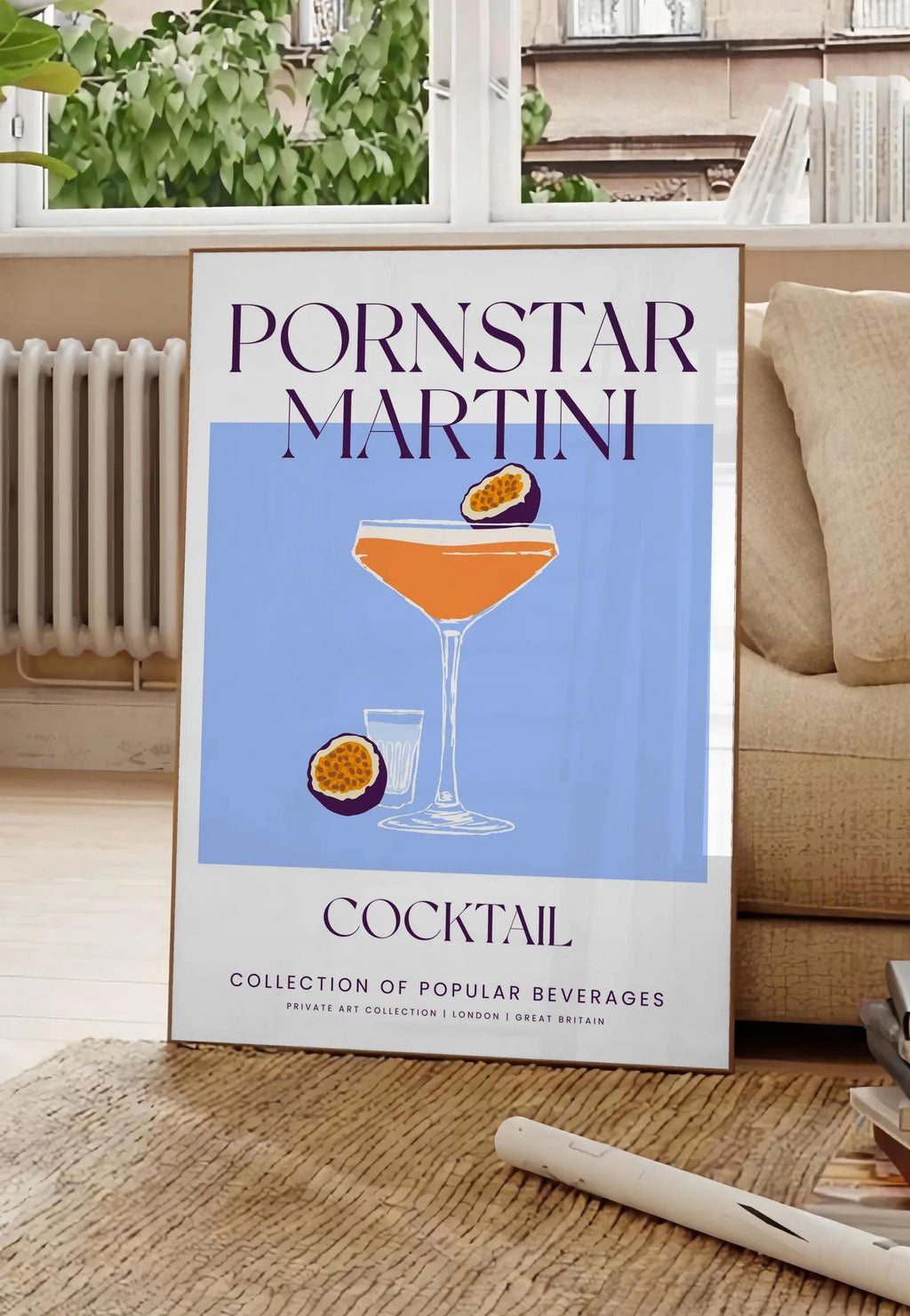 Poster affiche cocktail Pornstar Martini, posee au sol dans un salon parisien, devant une grande fenetre donnant sur un immeuble haussmannien, entre un ficus et un canape creme