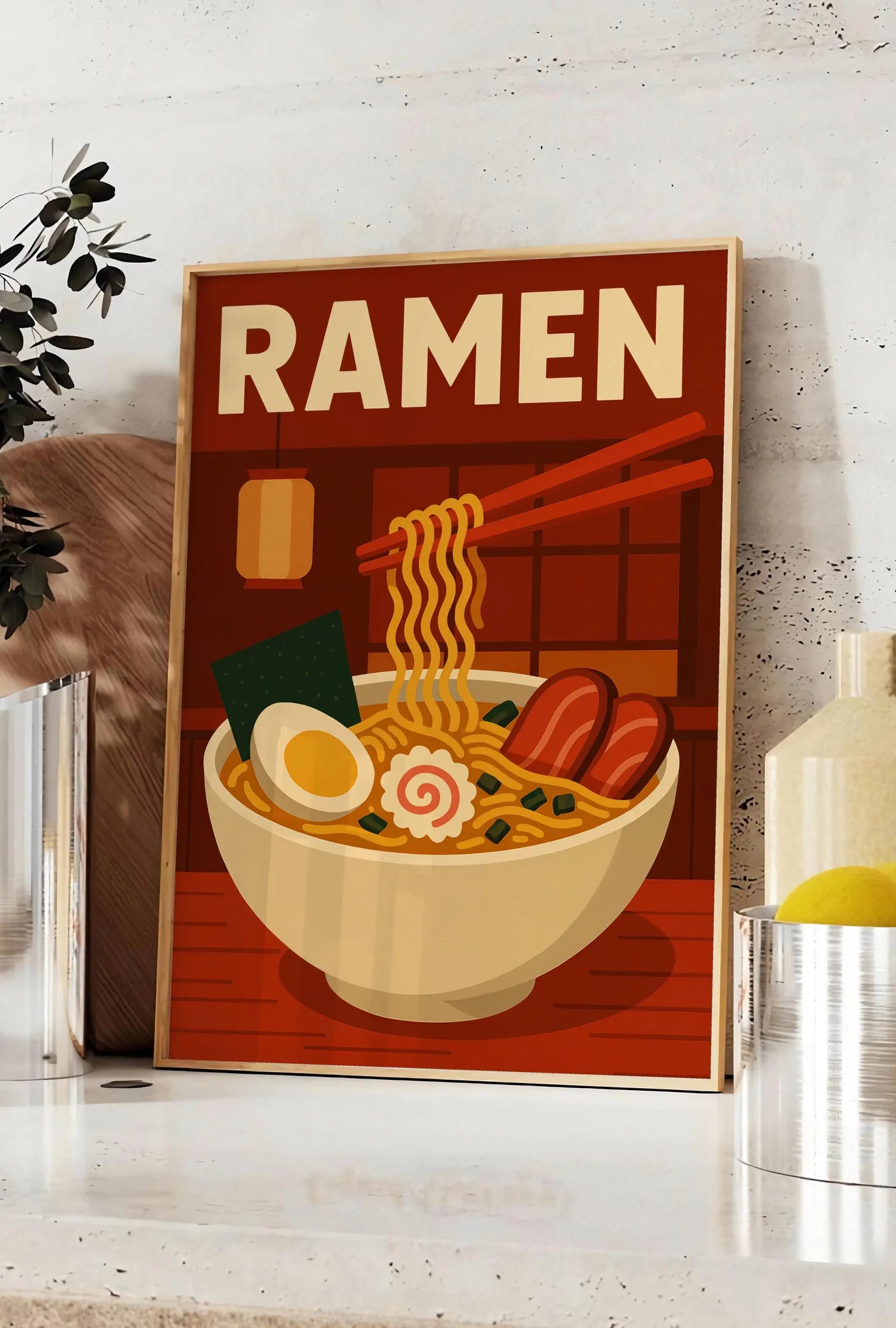 Affiche affiche ramen bol et nouilles soulevees a la baguette dans une cuisine rouge brique, posee sur un plan de travail de cuisine en pierre claire, entre une branche d'eucalyptus en vase et un bocal de citrons