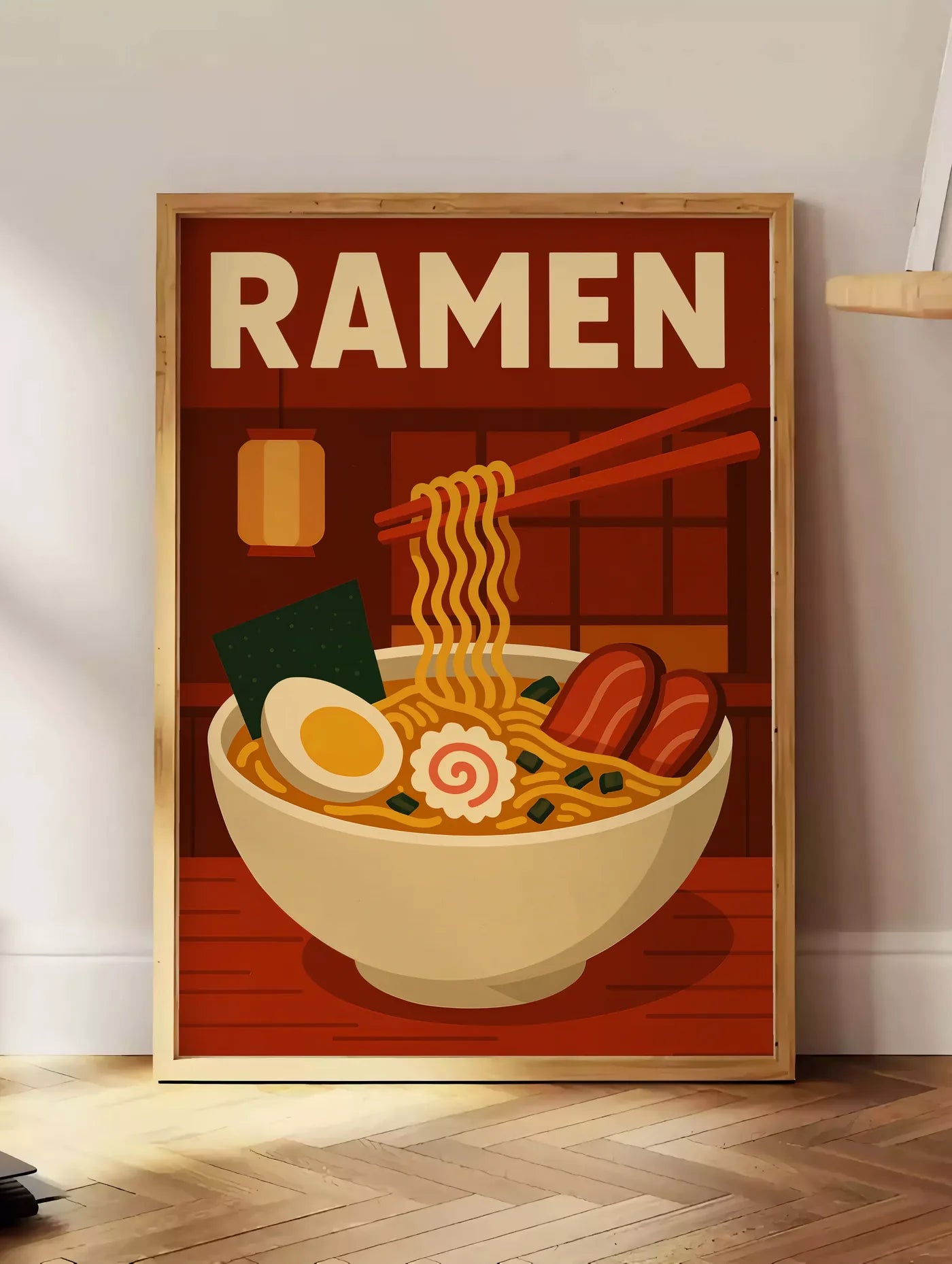 Estampe affiche ramen bol et nouilles soulevees a la baguette dans une cuisine rouge brique, posee au sol dans un coin salon, sur un parquet a chevrons, pres d'une table d'appoint en chene chargee de livres