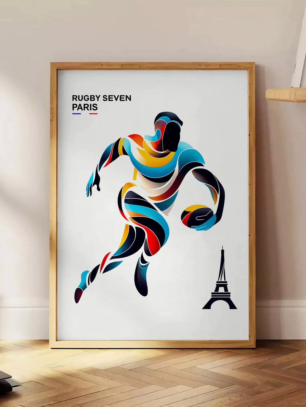 Estampe affiche rugby Paris, posee au sol dans un coin salon, sur un parquet a chevrons, pres d'une table d'appoint en chene chargee de livres