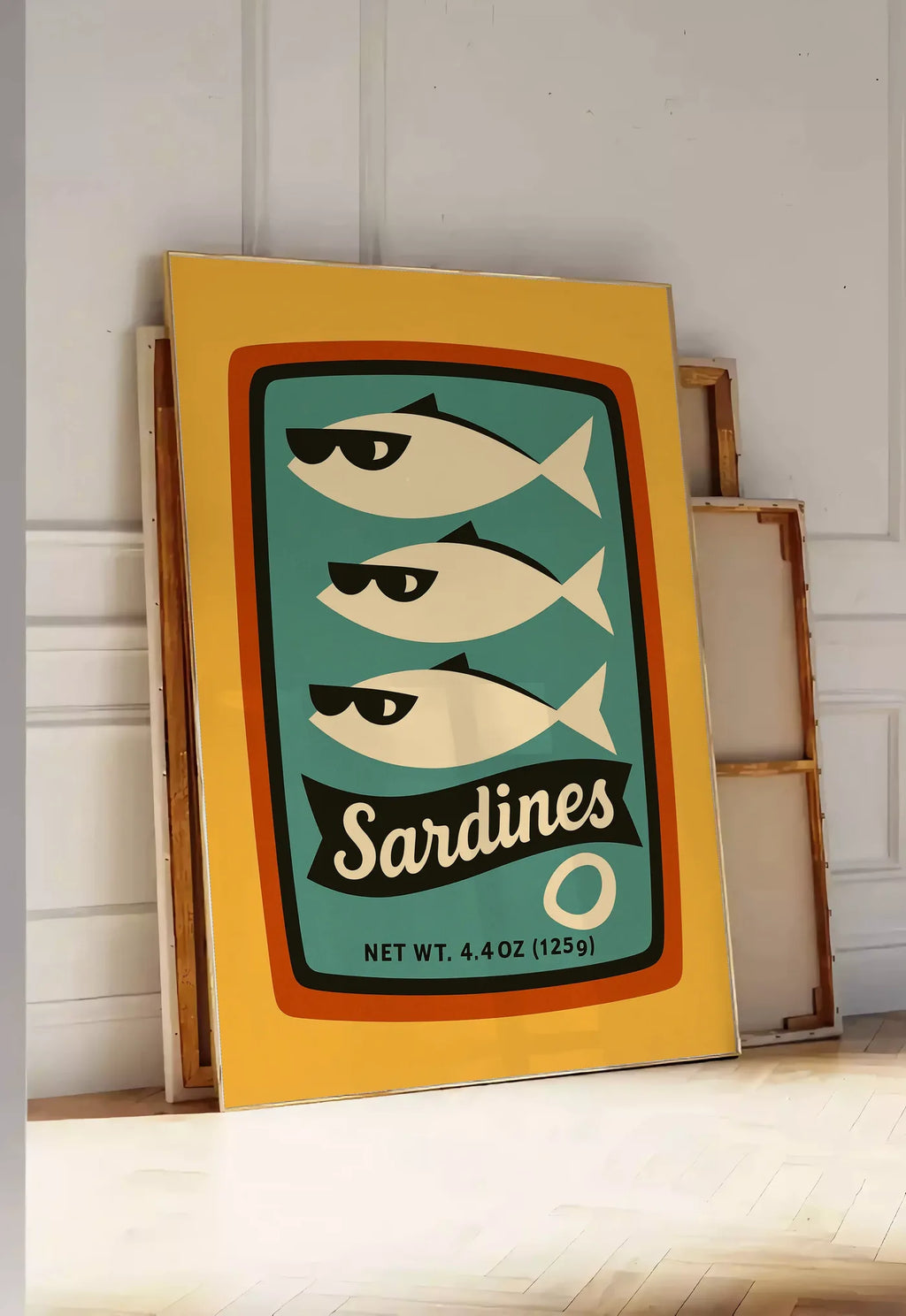 Tirage encadrable affiche cuisine sardines, posee au sol dans une entree lumineuse, contre un mur a panneaux blancs, a cote de chassis en bois empiles