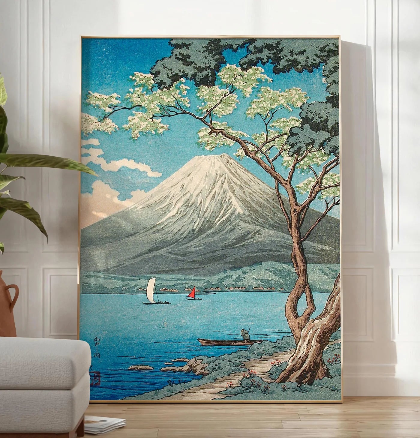 Reproduction affiche Mont Fuji estampe, posee au sol dans un salon minimaliste clair, a cote d'un canape beige et d'une plante verte, sur un parquet clair