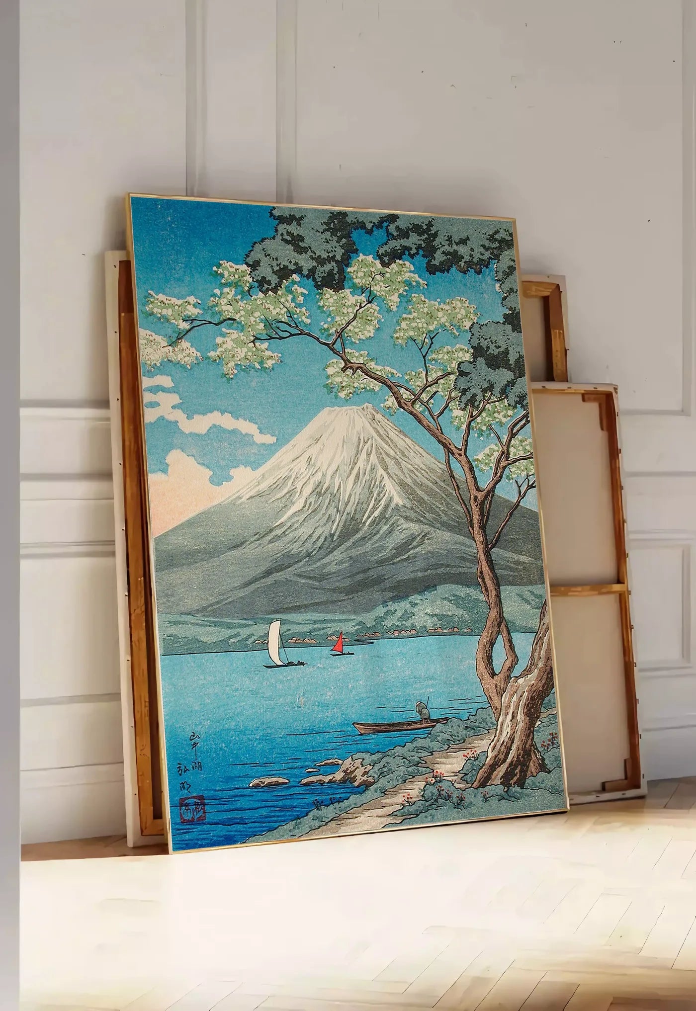 Tirage encadrable affiche Mont Fuji estampe, posee au sol dans une entree lumineuse, contre un mur a panneaux blancs, a cote de chassis en bois empiles