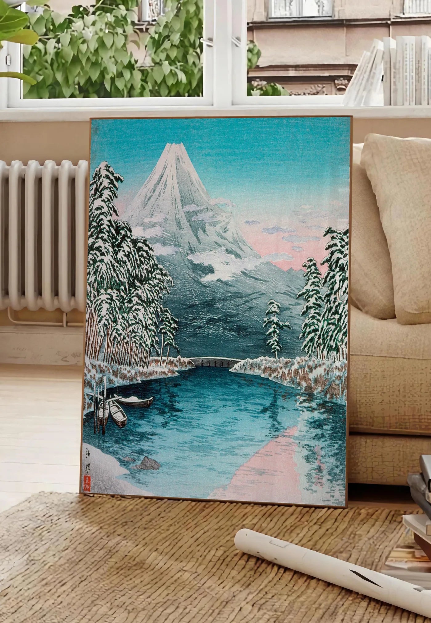 Poster affiche Mont Fuji estampe, posee au sol dans un salon parisien, devant une grande fenetre donnant sur un immeuble haussmannien, entre un ficus et un canape creme