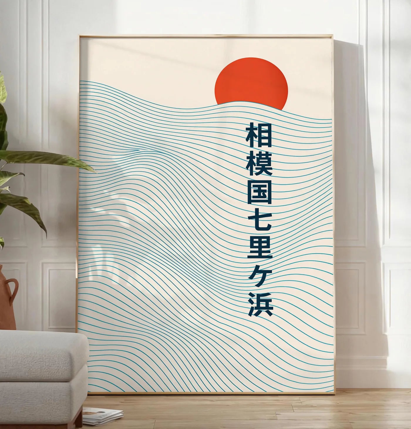 Reproduction affiche soleil rouge levant au-dessus de vagues japonaises au trait, posee au sol dans un salon minimaliste clair, a cote d'un canape beige et d'une plante verte, sur un parquet clair