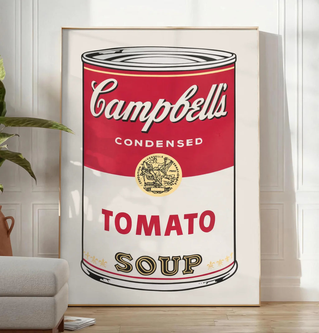 Reproduction affiche cuisine soupe tomate, posee au sol dans un salon minimaliste clair, a cote d'un canape beige et d'une plante verte, sur un parquet clair